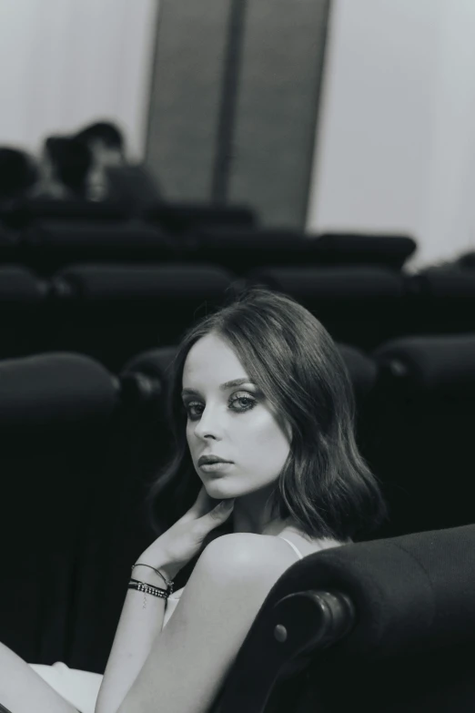 a black and white photo of a woman sitting in a chair, by Alexis Grimou, portrait anime kaya scodelario, sitting in a movie theater, portrait featured on unsplash, square