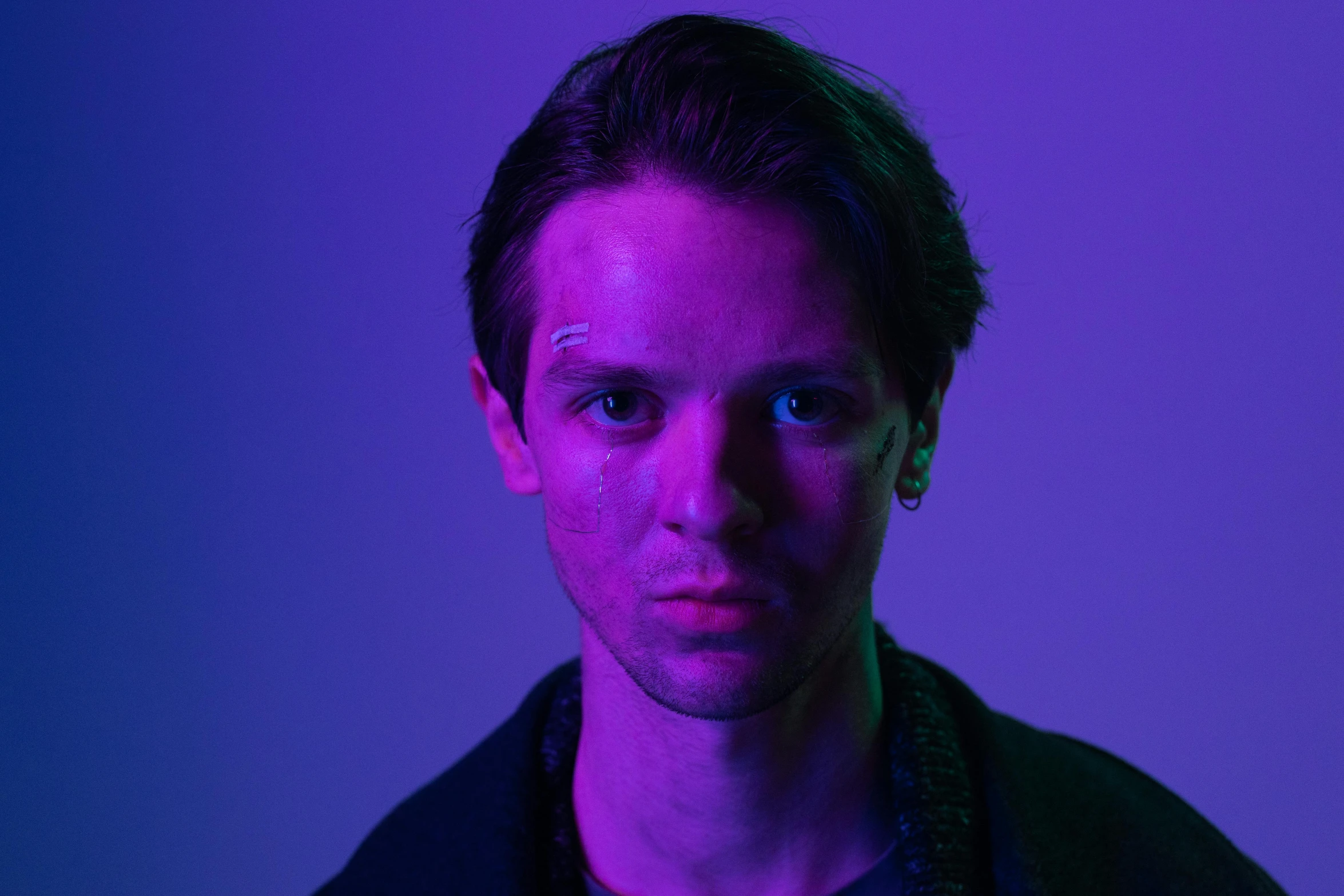 a man standing in front of a purple background, pexels contest winner, bauhaus, portrait of tom holland, bad light, purple lights, orelsan