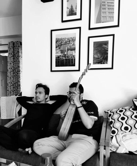 a couple of people that are sitting on a couch, an album cover, inspired by Sunil Das, reddit, hurufiyya, b&w!, guitarists, profile photo, at home