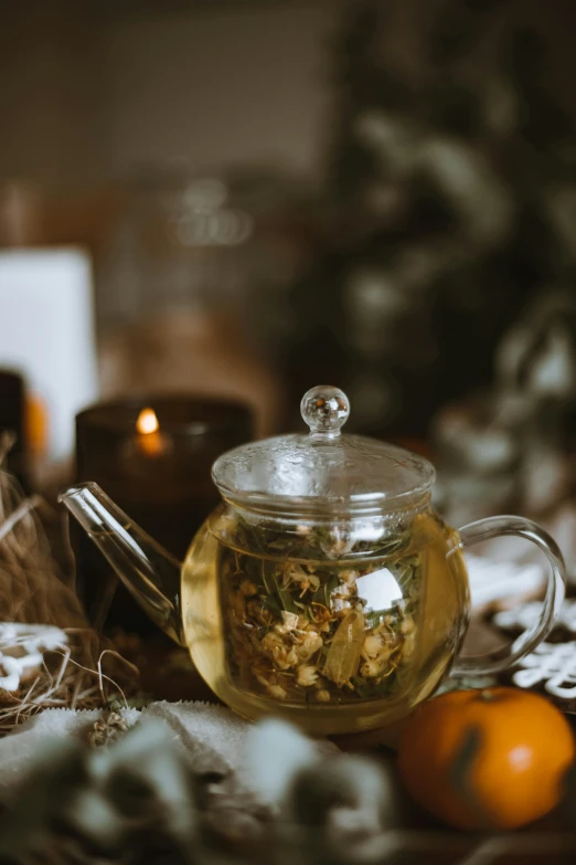 a glass teapot sitting on top of a table, a still life, pexels, floating candles, dried herbs, winter setting, indoor