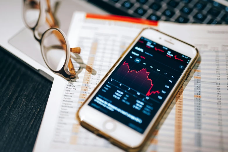 a cell phone sitting on top of a desk next to a keyboard, by Daniel Lieske, trending on pexels, analytical art, displaying stock charts, selling insurance, 🦩🪐🐞👩🏻🦳, close up portrait shot