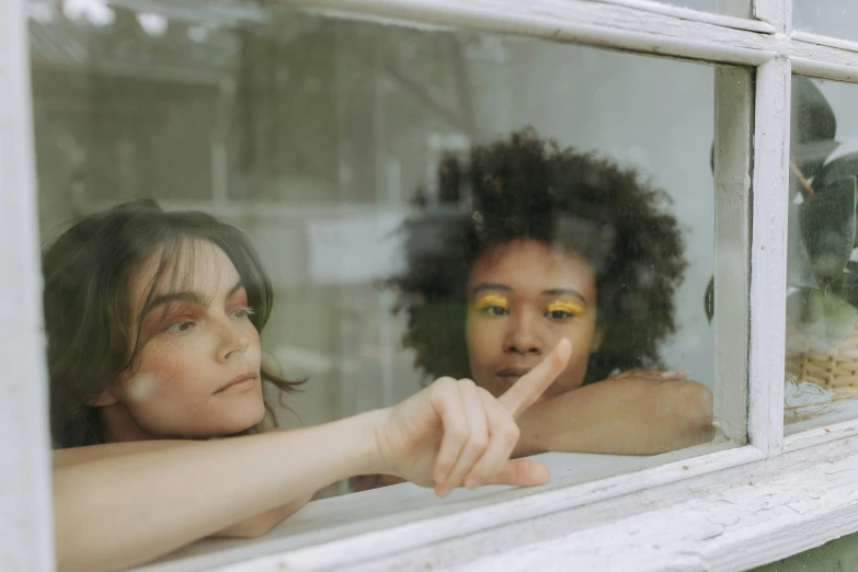 a couple of women looking out of a window, trending on pexels, with pointing finger, charli bowater and artgeem, with brown skin, 3 young and beautiful women