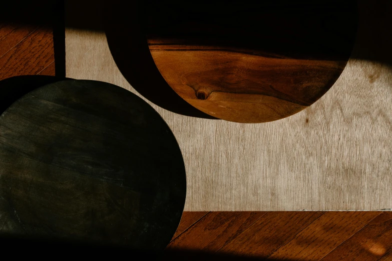 a clock sitting on top of a wooden table, an abstract sculpture, inspired by Arnold Newman, trending on unsplash, 3 moons, high angle close up shot, black and auburn colour pallet, shadows