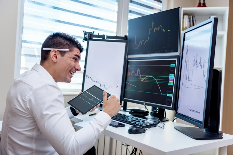 a man sitting at a desk in front of two computer monitors, pexels, analytical art, cryptocurrency, everyone having fun, waveforms on top of square chart, digital medical equipment