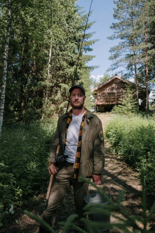 a man standing in the woods with a fishing pole, a portrait, by Anato Finnstark, pexels contest winner, standing outside a house, tom hardy, midsommar - t, daniil kudriavtsev