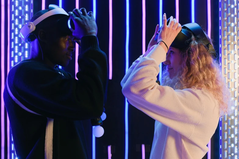 a couple of people standing next to each other, a hologram, pexels contest winner, interactive art, black blindfold, wearing a headband, white and black clothing, ( ( theatrical ) )