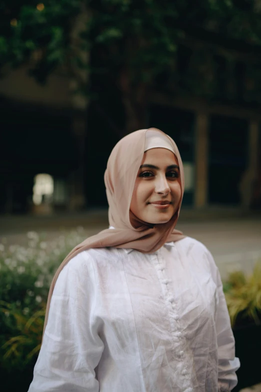 a close up of a person wearing a headscarf, wearing a light shirt, vp of marketing, standing, bay area