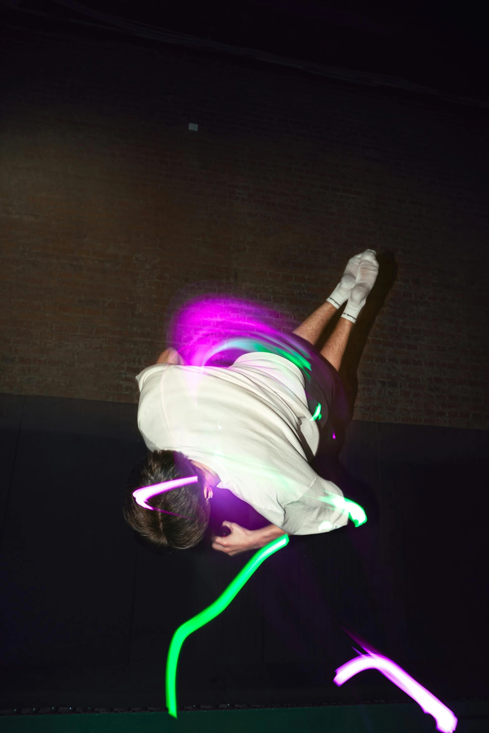 a man flying through the air while riding a skateboard, a hologram, inspired by Bruce Nauman, happening, neon rim light, low-light photograph, head down, sassy pose