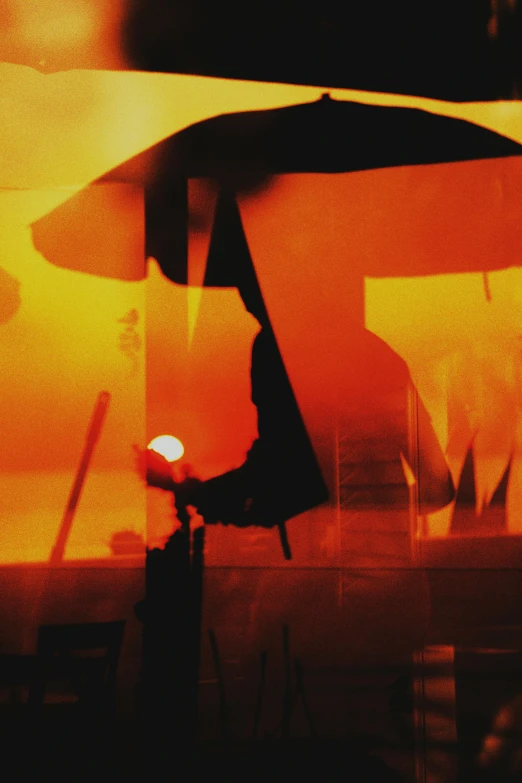 a person holding an umbrella in the rain, an album cover, inspired by Georges de La Tour, conceptual art, smoke and orange volumetric fog, 1999 photograph, vietnam, silhouette :7