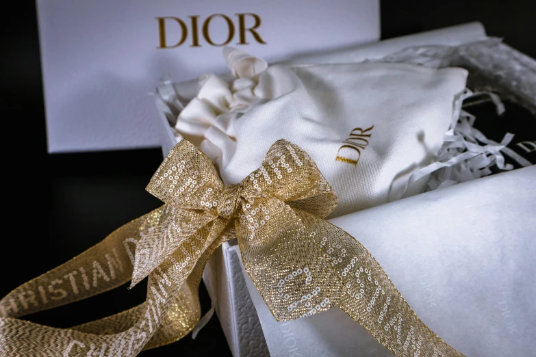 a close up of a white box with a gold ribbon, inspired by Albert Dorne, instagram, baroque, dior, pouches, thumbnail, studio shot