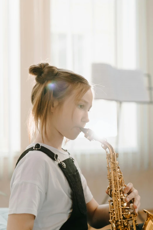 a little girl that is playing a saxophone, trending on pexels, focused on her neck, light haze, student, aged 13