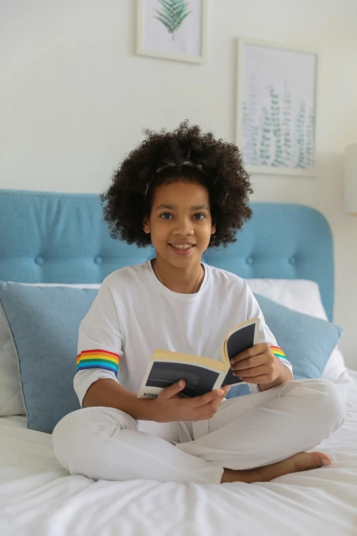 a young girl sitting on a bed reading a book, happening, lgbtq, with afro, wearing a light blue shirt, instagram photo