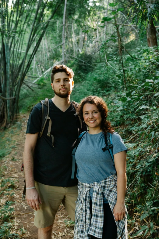 a man and a woman standing next to each other on a trail, zachary corzine, profile image, group photo, lush surroundings