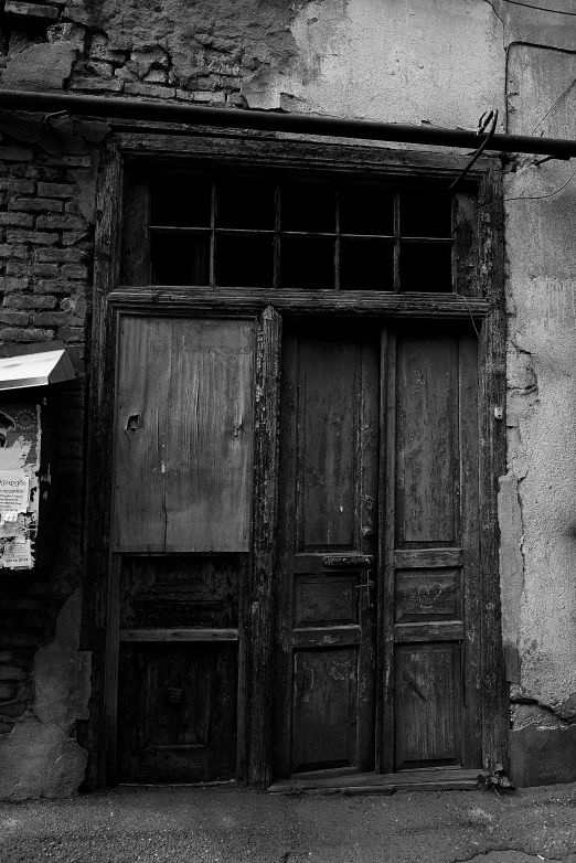 a black and white photo of an old building, a black and white photo, unsplash, wood door, shanghai, very poor, the store