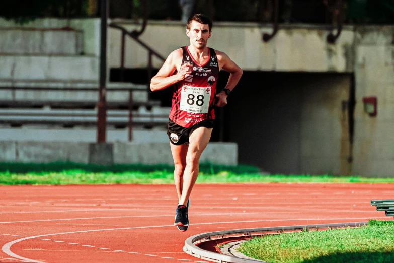 a man running in a race on a track, a portrait, by Matt Stewart, pexels contest winner, wearing red shorts, 🚿🗝📝, panoramic shot, university