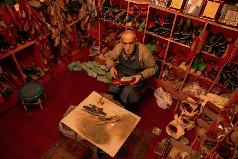 a man sitting in a room filled with lots of shoes, a portrait, process art, old man doing with mask, tehran, avatar image, pyrography