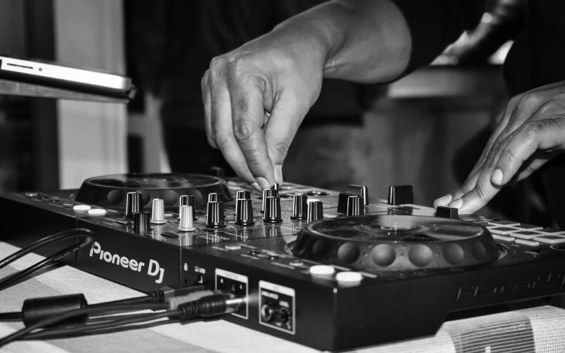 a close up of a person using a dj controller, a black and white photo, process art, 15081959 21121991 01012000 4k, event, featured, hand on table