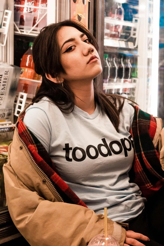 a woman wearing a t - shirt that says toooooooooooooooooooooooooooooooooooooo, an album cover, trending on unsplash, antipodeans, raphael hopper, sitting on a store shelf, gemma chan girl portrait, mukbang