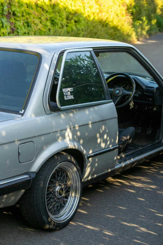 a car parked on the side of the road with its door open, bmw e 3 0, profile image, detailing, aftermarket parts