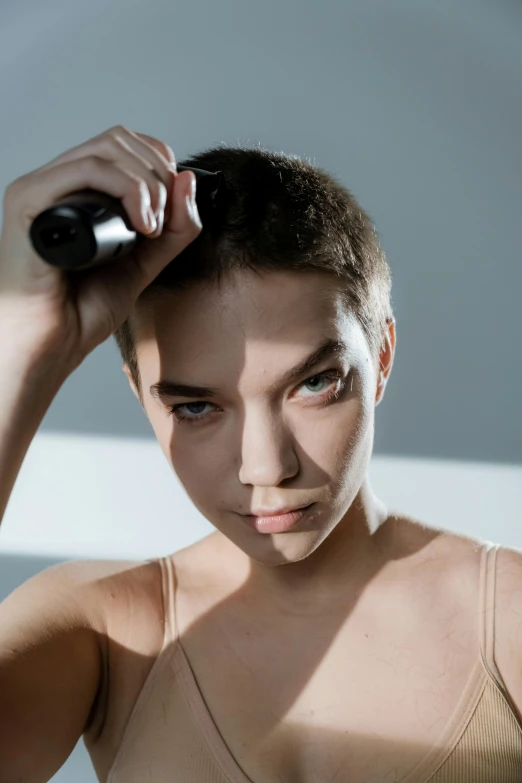 a woman brushing her hair with a hair dryer, by Adam Marczyński, trending on pexels, bauhaus, crew cut, portrait of barbara palvin, non-binary, thin young male