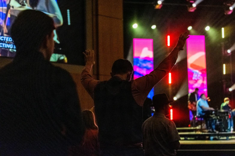 a group of people standing on top of a stage, worship, over his shoulder, rafeal albuquerque, during the night