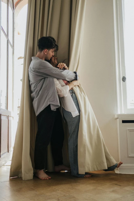 a man and a woman hugging in front of a window, pexels contest winner, fully covered in drapes, leaving a room, gif, ignant