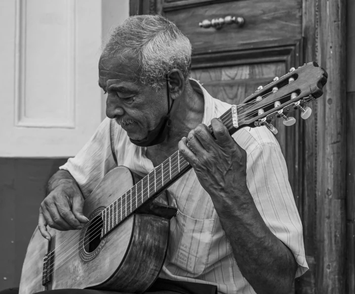 a black and white photo of a man playing a guitar, by Joze Ciuha, pexels contest winner, cuban setting, old man doing hard work, square, gorgeous lady