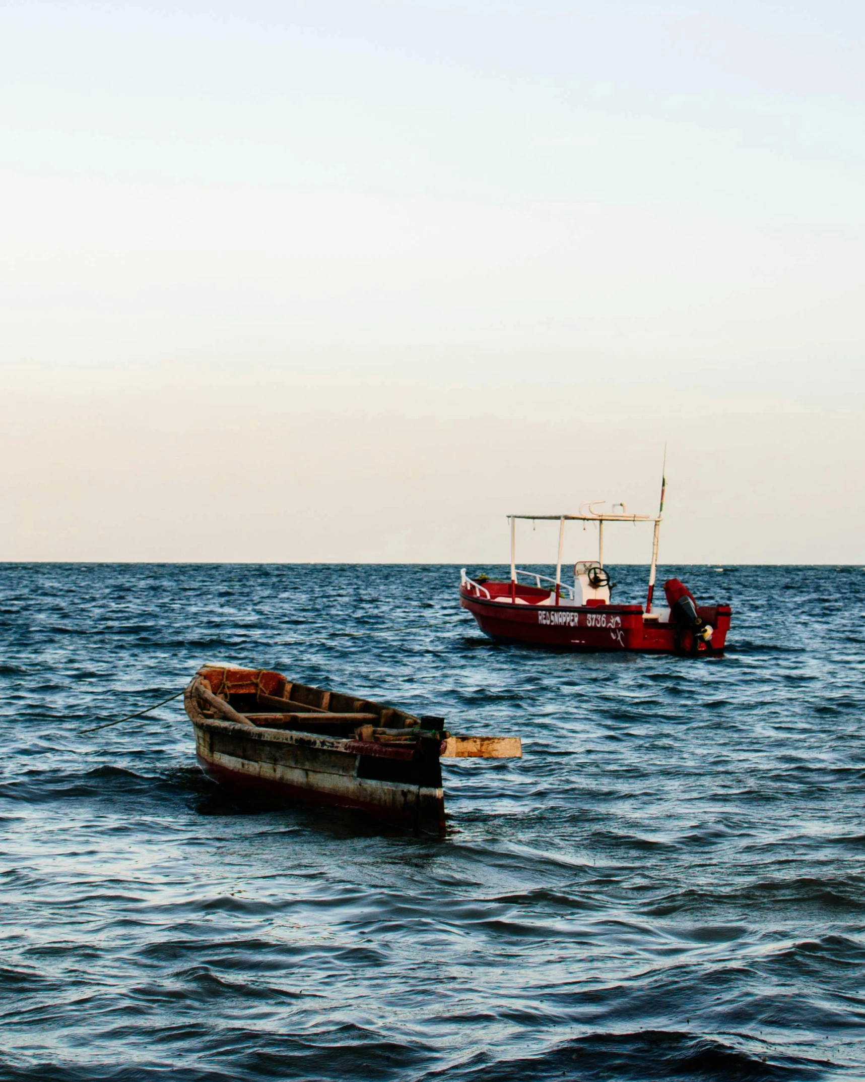 a couple of boats floating on top of a body of water, pexels contest winner, hurufiyya, nubian, bloody ocean, thumbnail, lgbtq