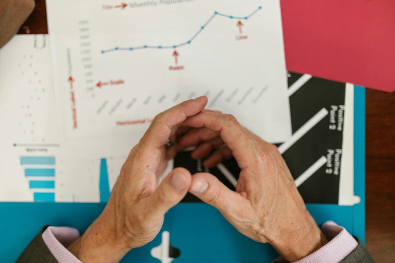 a close up of a person using a cell phone, analytical art, papers on table, age lines, charts, hands reaching for her