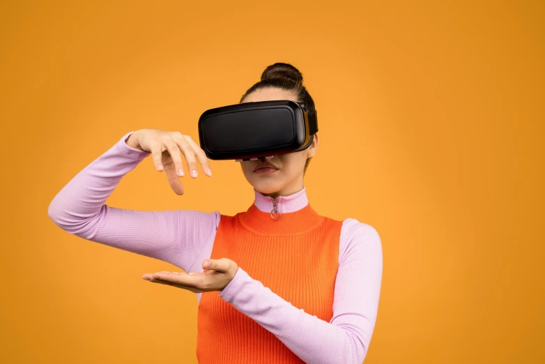 a woman wearing a virtual reality headset on an orange background, trending on pexels, striking pose, educational, rectangle, black