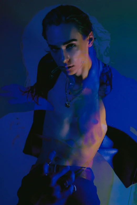 a shirtless man sitting on top of a bed, an album cover, inspired by Jean Malouel, trending on pexels, digital art, blue body paint, robert sheehan, databending, fashion color studio lighting