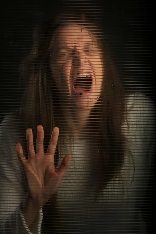 a woman standing in front of a window with her hands in the air, a picture, inspired by Peggy Bacon, computer art, horror saw teeth, closeup!!!!!!, the man is screaming and sad, picture through the screen