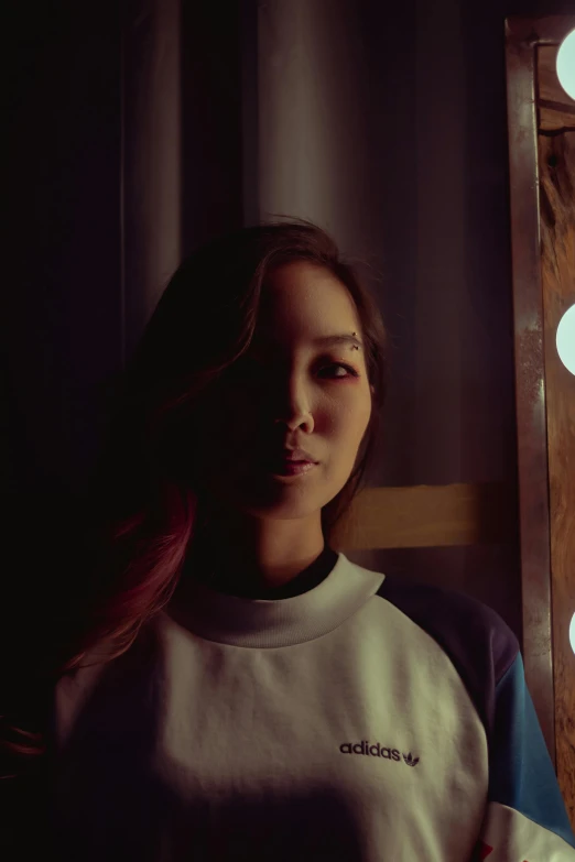 a woman standing in front of a lighted mirror, inspired by Jung Park, unsplash, portrait of kpop idol, shigeto koyama, studio photo, low quality photograph