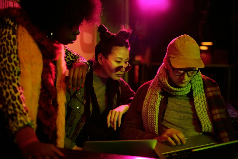 a group of people standing around a laptop computer, pexels, renaissance, magenta lighting. fantasy, worksafe. cinematic, lesbians, photograph of three ravers