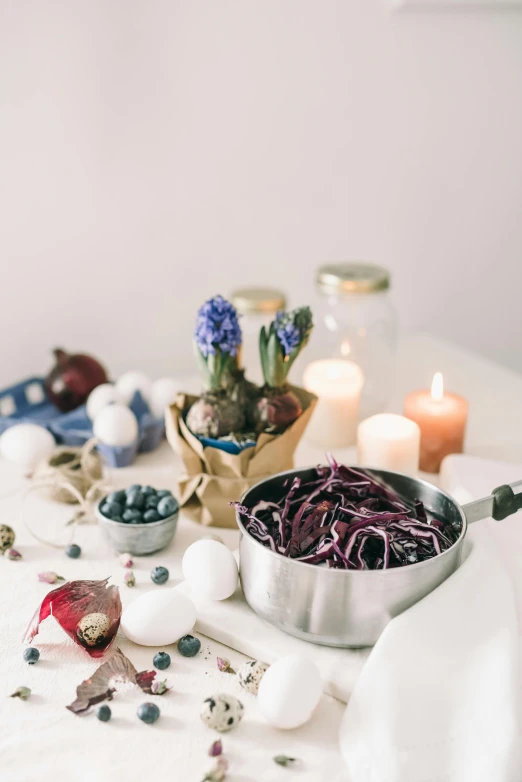 a table topped with bowls of food next to candles, a still life, unsplash, violet hair, with a white background, cook, indoor picture