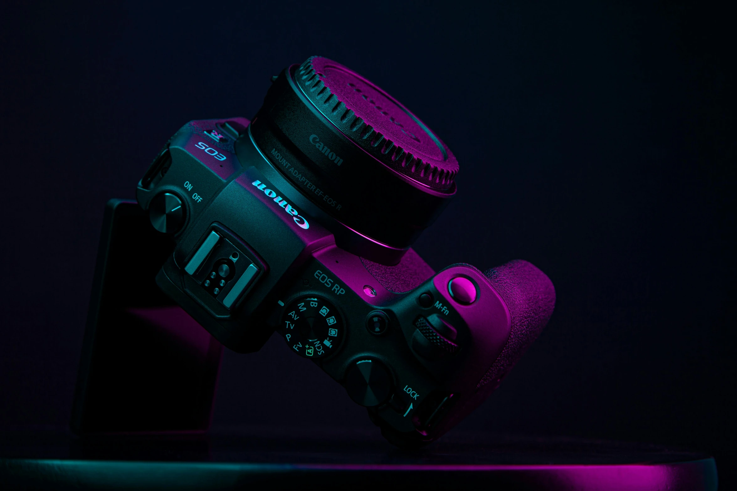 a close up of a camera on a table, by Adam Marczyński, unsplash contest winner, art photography, purple volumetric lighting, crown of (pink lasers), background canon, full body profile camera shot