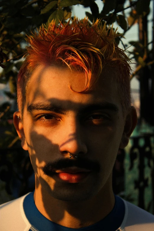 a man with red hair and a moustache on his face, inspired by Elsa Bleda, featured on reddit, sunset lighting ominous shadows, punk hairstyle, headshot photo, 1 6 years old