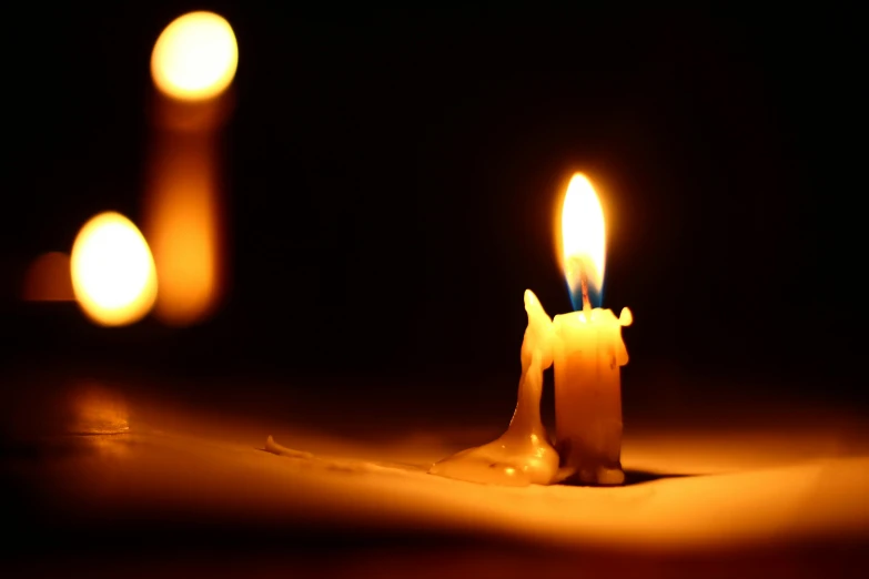 a couple of lit candles sitting on top of a table, profile image, candle dripping white wax, on its own, light source from the left