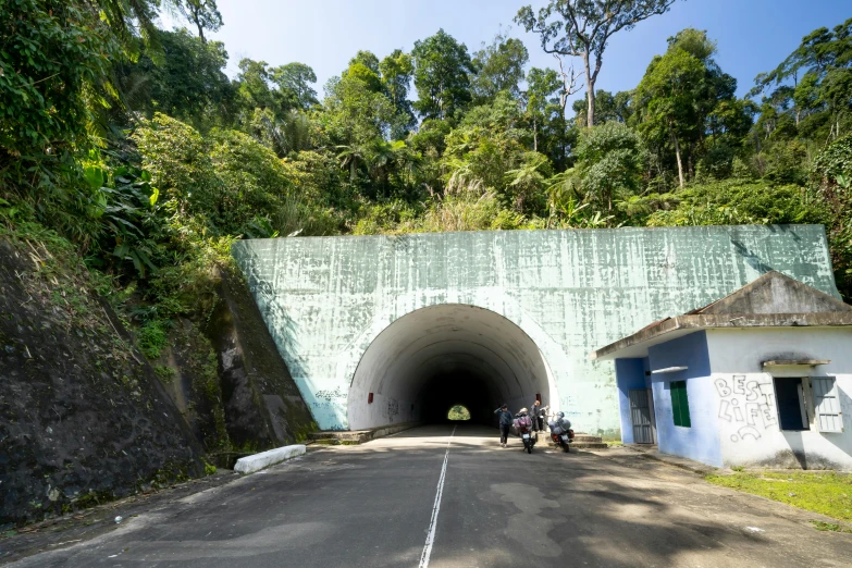 there is a tunnel on the side of the road, a portrait, sumatraism, avatar image, one motorbike in center of frame, slide show, thumbnail