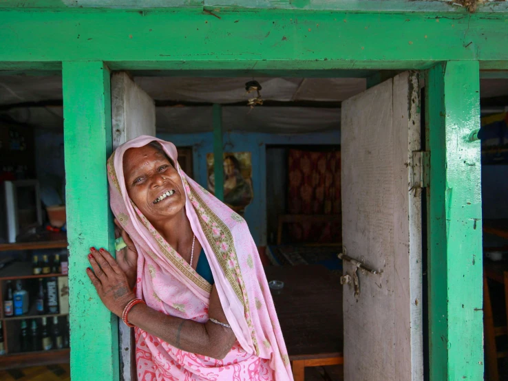 a woman that is standing in a doorway, a portrait, pexels contest winner, tribals, draped in fleshy green and pink, she is happy, thumbnail