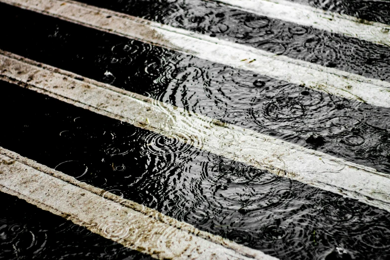 a person walking in the rain with an umbrella, water ripples, crosswalk, instagram post, striped