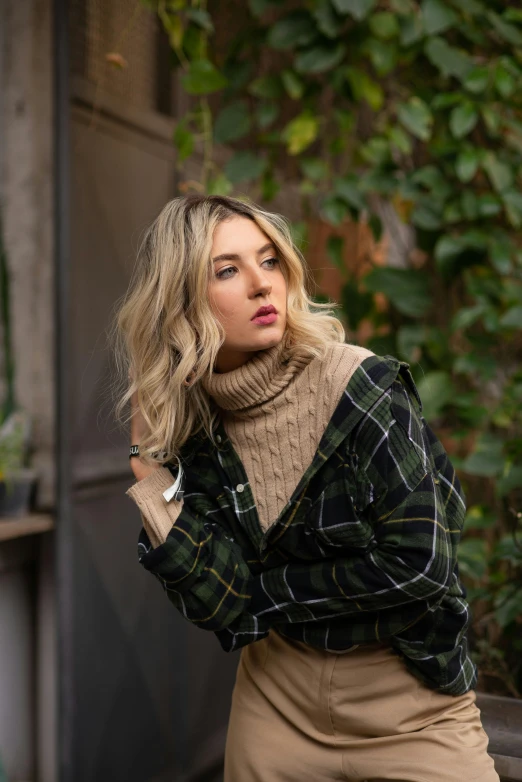 a woman sitting on a bench wearing a sweater and skirt, a portrait, inspired by Jane Kelly, trending on pexels, tartan garment, wearing a turtleneck and jacket, curly blonde hair | d & d, model shoot