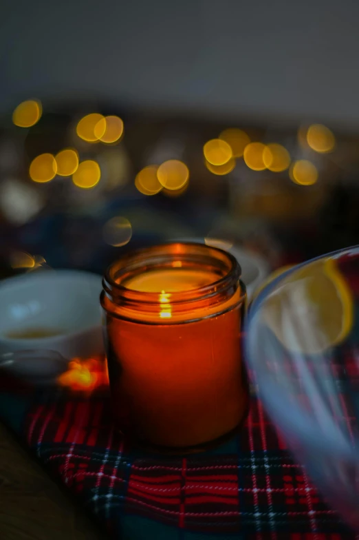 a candle that is sitting on a table, pexels, inside a glass jar, warm yellow lights, winter setting, honey