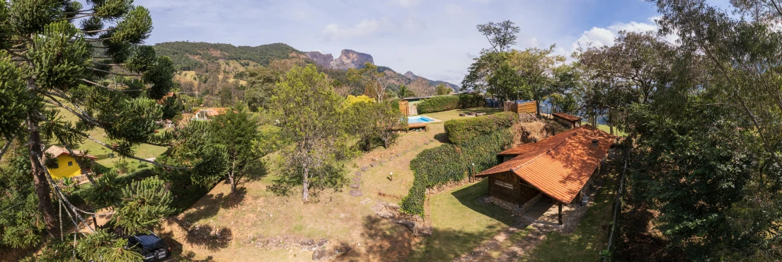 a bird's eye view of a house surrounded by trees, by Felipe Seade, moutain in background, bolsonaro, view, campsites