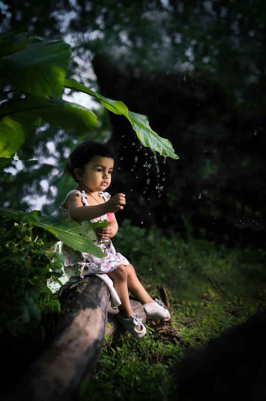 a little girl sitting on top of a tree branch, a picture, by Basuki Abdullah, pexels contest winner, light rain, sitting on a leaf, splashing, portait image