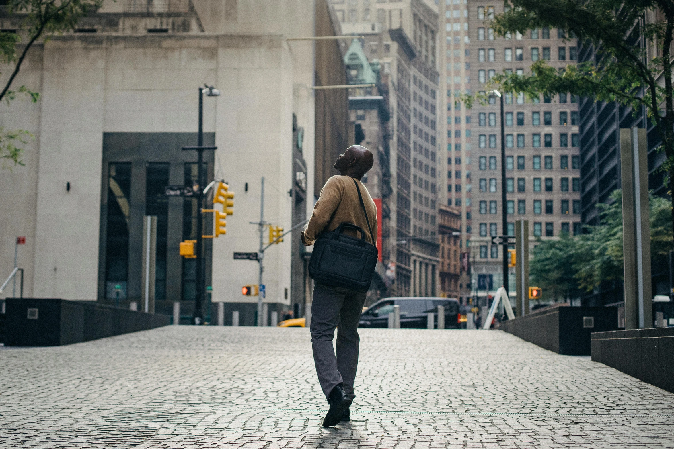 a woman walking down a cobblestone street, by Carey Morris, pexels contest winner, happening, watching new york, the man have a backpack, intersection, in full growth from the back