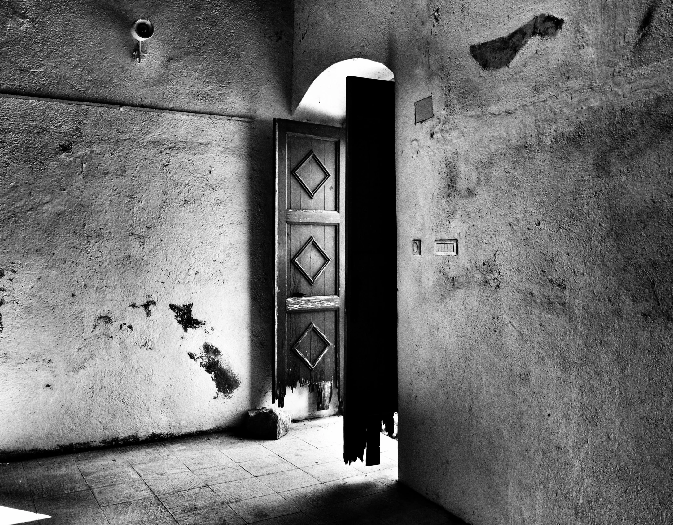 a black and white photo of an open door, by Kristian Zahrtmann, flickr, arte povera, cave prison, house interior, simone graci, vibrant contrast