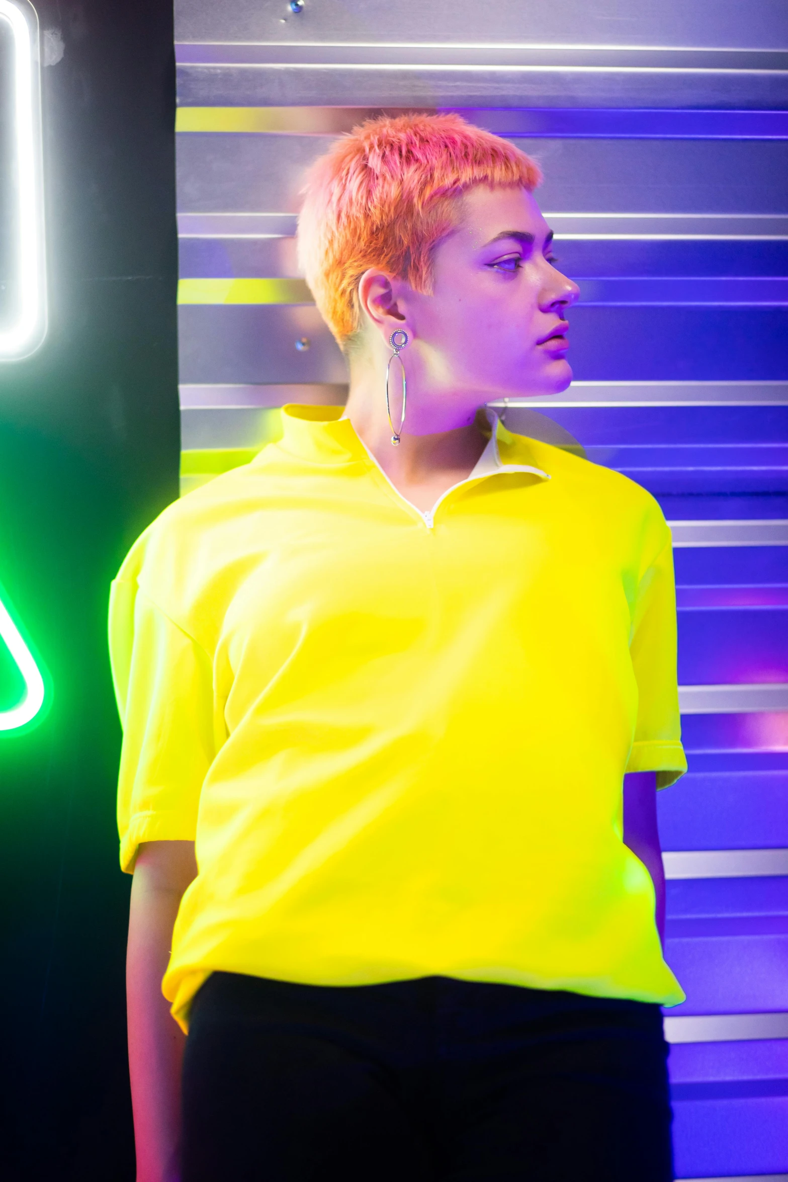 a woman standing in front of a neon sign, trending on pexels, wearing polo shirt, yellow spiky hair, bella poarch, androgyny