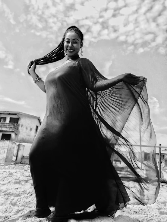 a black and white photo of a woman in a long dress, by Lucia Peka, aruba, cardi b, having fun. vibrant, in africa