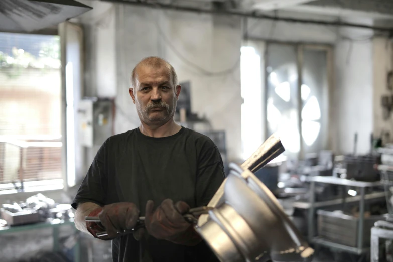 a man standing in a kitchen holding a pot, a portrait, pexels contest winner, arbeitsrat für kunst, scrap metal on workbenches, profile image, turkey, introduction factory photo